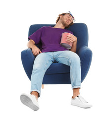 Man with 3D glasses and popcorn sleeping in armchair during cinema show on white background