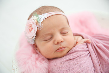 Fototapeta na wymiar Adorable newborn girl lying in baby nest, closeup