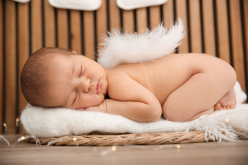 Cute newborn baby as Christmas angel in decorated studio