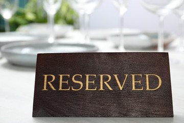 Table setting with RESERVED sign in restaurant