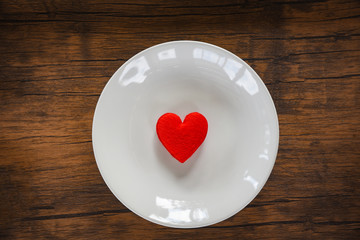 Valentines dinner romantic love food and love cooking Red heart on white plate romantic table setting decorated with red heart wooden