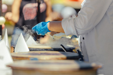 Woman cooking pancakes outdoors