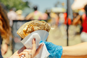 Woman's hand receiving a crepe at a food fair