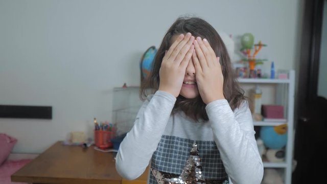 hide and seek. little girl covered her eyes face with her hands peek a boo waiting for a surprise. slow motion video. lifestyle teen girl playing bo-peep. childhood concept game hy - spy