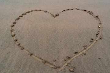 Heart background drawn on the sand of a beach, love background valentine day with happy holiday.