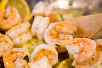 Delicious Shrimp Scampi prepared in pan with melted butter, garlic, fresh parsley red pepper flakes and lemon slices