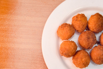 Cheese balls, Breaded mozzarella cheese balls with tomato in white dish on wood blackground
