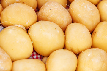 Fototapeta na wymiar Close-up of spherical cheese wheels stacked in a basket