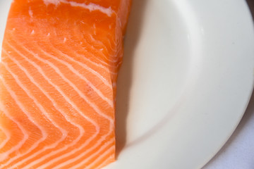 Salmon in white dish on white blackground.