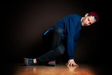 closeup photo of male break dancer performing stance against dark background b