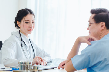 Fototapeta premium Old Patient men Talking with Medical Doctor women in clinic office