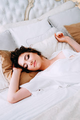 Obraz na płótnie Canvas Beautiful brunette in silk robe sleeping on the bed