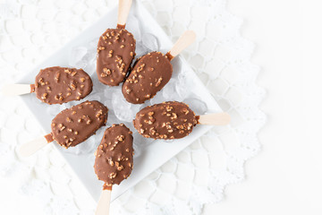 caramel and chocolate nut covered ice cream sticks on ice