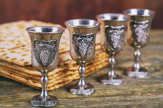 Red kosher wine four of matzah or matza Passover Haggadah on a vintage wood background