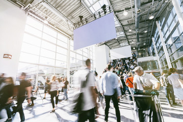 blurred people walking in a modern hall of a trade fair