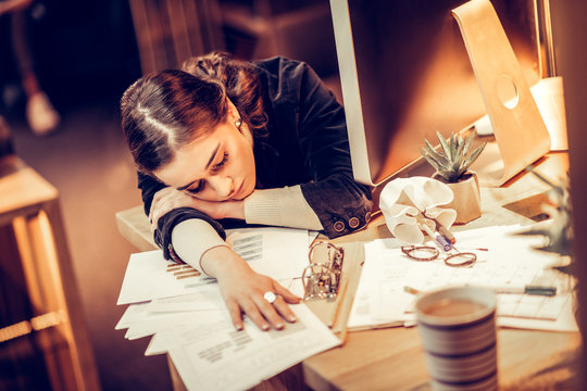 Exhausted young woman putting her head on arm