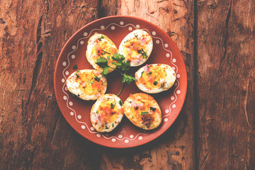 Fried hot boiled egg masala is a popular healthy breakfast or starter menu from India. With onion,...