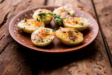 Fried hot boiled egg masala is a popular healthy breakfast or starter menu from India. With onion, coriander, black pepper, tomato and salt sprinkled over half of eggs