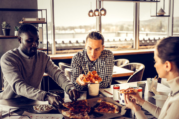 Attentive stylish man staring at piece of pizza