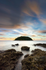 Sea and boulders foreground with long exposure shot when sunset. Shot at Yanui Beach, Phuket, Thailand.