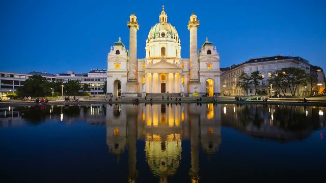 The beautiful Karlskirche (St. Karls Church) in Vienna, Austria at night with clean reflection in the water and deep blue sky.