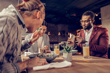 Hungry blonde male eating salad with pleasure