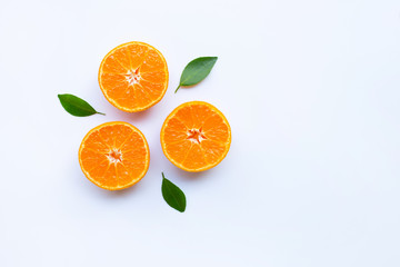 Fresh orange citrus fruit with green leaves on white.