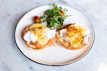 Eggs Benedict, English muffin topped with a poached egg, smoked salmon, and hollandaise sauce.