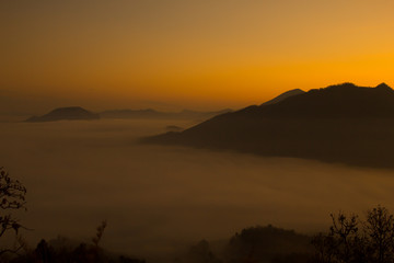 Beautiful sky sunrise. Mountain layer in morning sun ray and winter fog.