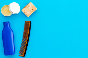 shampoo bottle and comb for man care in barbershop blue background top view mockup