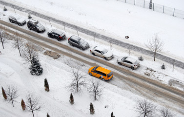 Yellow taxi car parked on a snowy street
