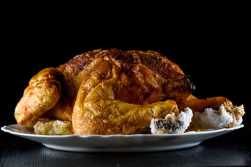 fried chicken whole, on a white plate on a wooden background