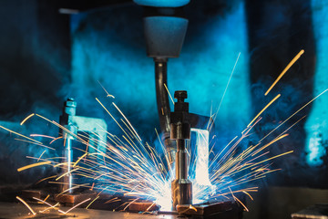 Industrial robot is welding car part in factory