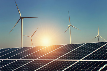 solar panel and wind turbine with sunrise background. concept clean energy