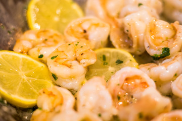 Delicious Shrimp Scampi prepared in pan with melted butter, garlic, fresh parsley red pepper flakes and lemon slices