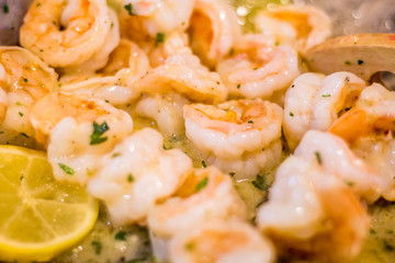 Delicious Shrimp Scampi prepared in pan with melted butter, garlic, fresh parsley red pepper flakes and lemon slices