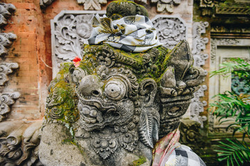 Traditional Balinese stone statue in front of Hindu temple in Ubud town of Bali, Indonesia.