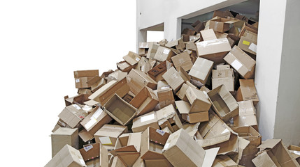 Discarded brown colored corrugated paper carton boxes overflowing from a recycle chamber, isolated...