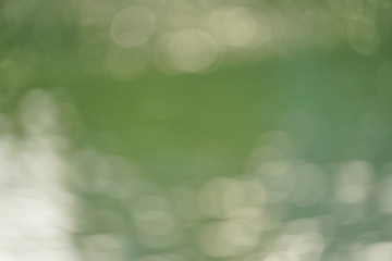 Abstract green nature blurred background with bright sunlight, flare and bokeh
