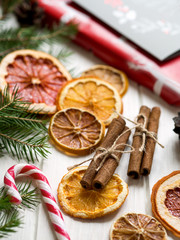 Christmas decoration with dry orange, cinnamon sticks and trees brunches on white table. Dry citrus: orange, lemon, grapefruit.