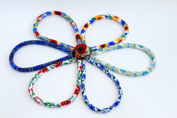 Beaded crochet necklaces with floral pattern on white background. Bead rope, seed beads,