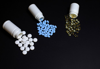 Different Medical pills, tablets and capsules on a black background