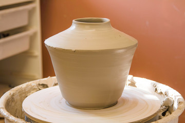 Artist potter in the workshop sculpting ceramic vase. Hands closeup. Small artistic craftsmen business concept. 