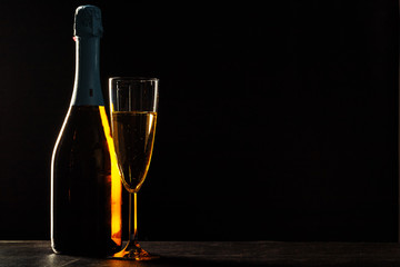 bottle of champagne and glasses over dark background