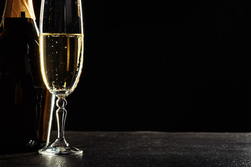 bottle of champagne and glasses over dark background