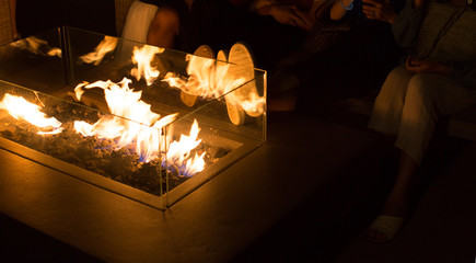 Happy Family in Autumn by the Fireplace. Feet of Family and Friends Near Fireplace. Warming by Fireside. Family Relaxing at Home. Holiday Vacation Concept.