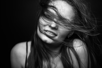 Dramatic black and white portrait of a beautiful girl on a dark background