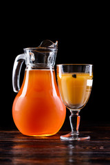 Russian cold rye drink Kvas in a glass and a jug on the kitchen table in a rustic style. Kvass from bread, rye malt, sugar and water. Copy space