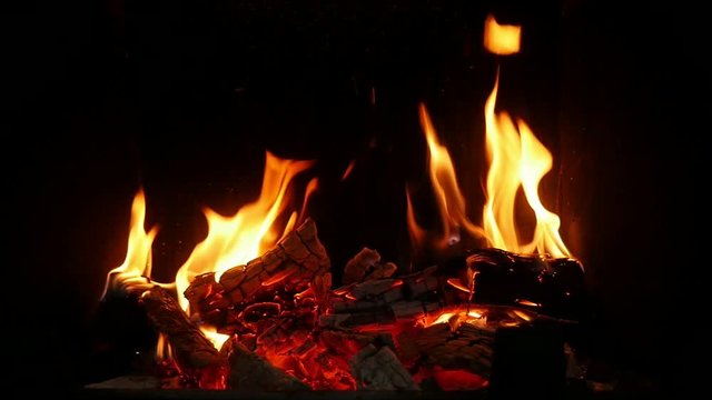 Burning spurts of flame turning wooden balks into grey ash in a fireplace 