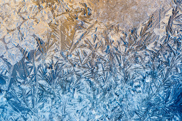 Blue beautiful winter frost patterns, abstract frost flowers texture on the road